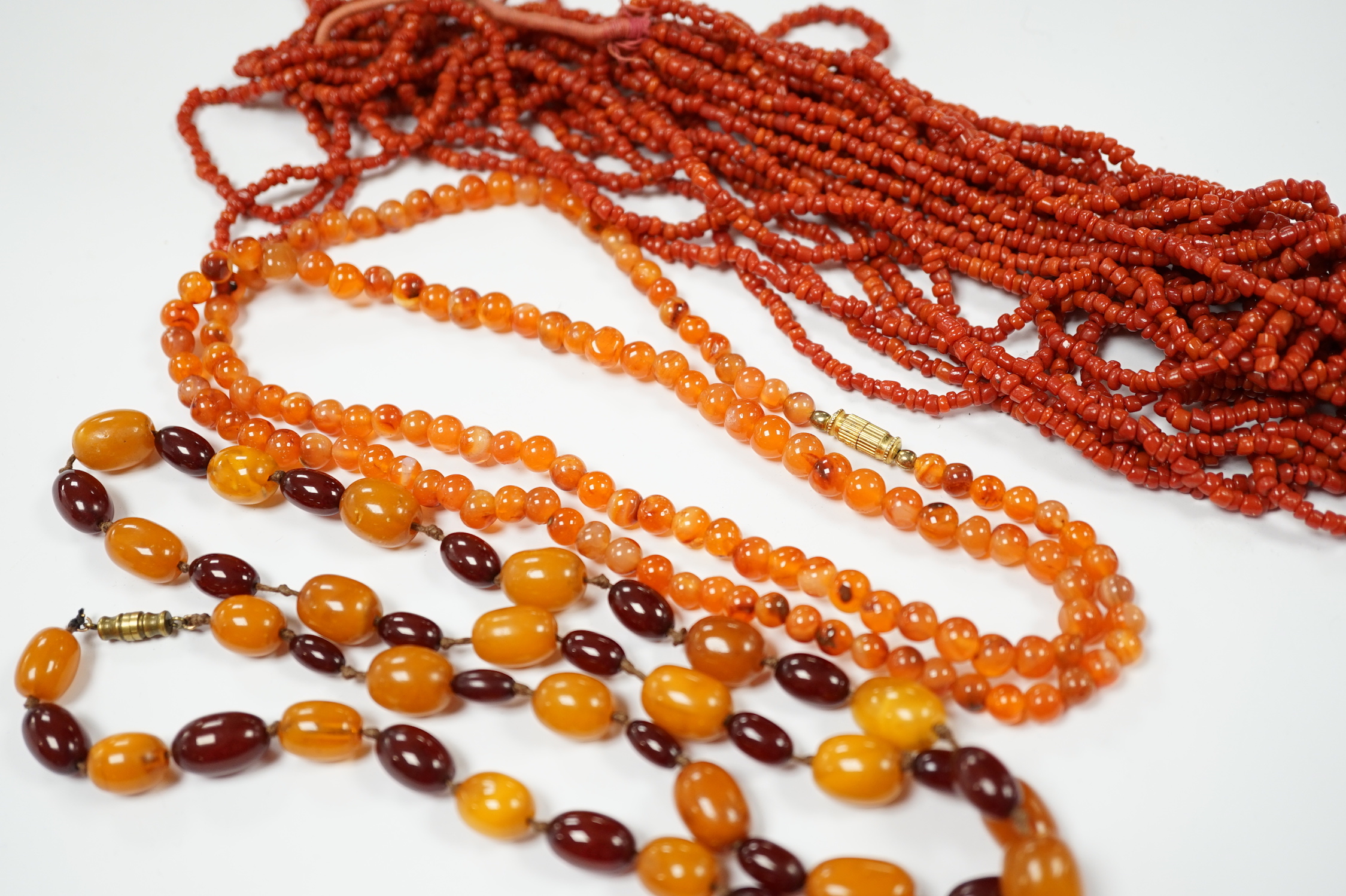 A single strand amber and simulated cherry amber bead necklace, 72cm, gross weight 33 grams, together with two other necklaces including agate bead.